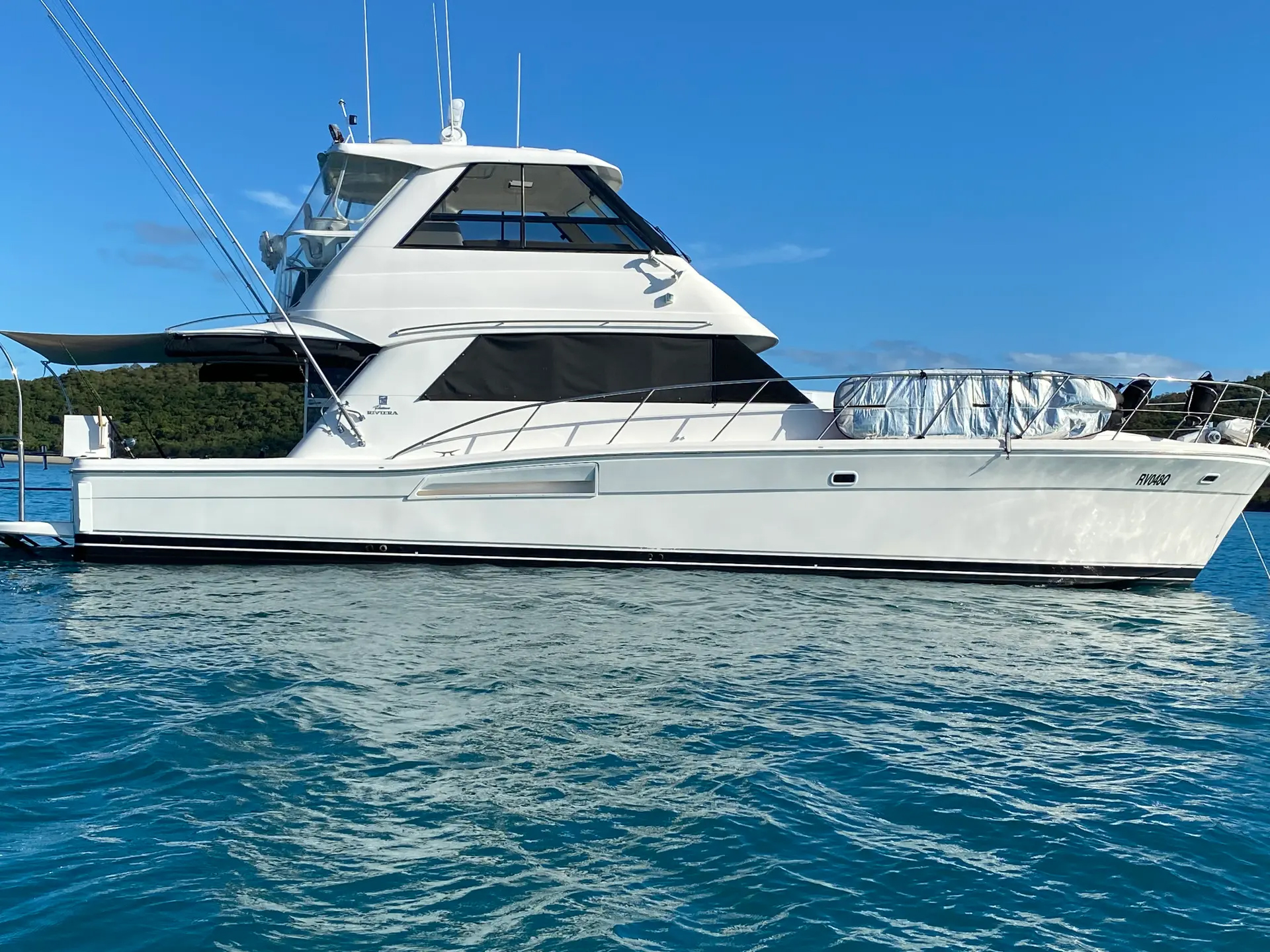 A person relaxing on a boat deck with calm waters in the background.