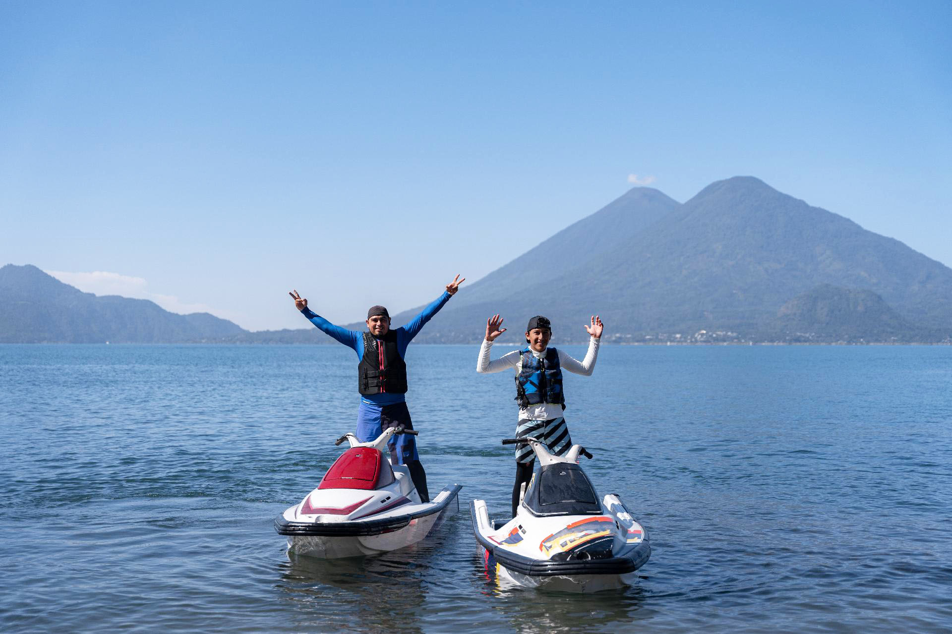 People enjoying jet skiing and wakeboarding behind a boat.